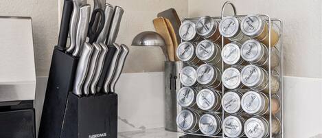 Una encimera de cocina con un bloque de cuchillos y un especiero.