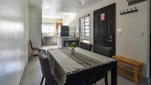 A dining area with a table set for four, a bench, and a door with a no-smoking sign. - For 6, NO stairs, beach, Costco, well located! (Mérida)