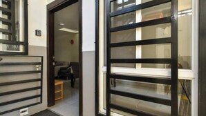 A hotel entrance with a metal gate and a door leading inside. - For 6, NO stairs, beach, Costco, well located! (Mérida)
