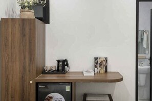 A wooden counter with a coffee machine, a cup, and a framed picture.