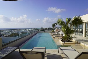 Una piscina al aire libre, camas de piscina gratis, sombrillas