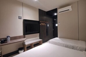 A hotel room with a bed, a TV, a bench, a coat rack, and an air conditioning unit. - Urban Inn Myra Meranti (Puchong)