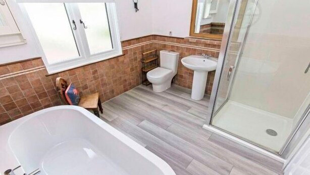 Un baño con bañera, inodoro, lavabo y cabina de ducha de vidrio.