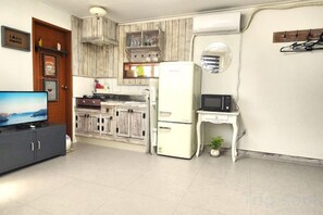 A compact kitchen with a refrigerator, microwave, and a small dining table. - Sea Scenery Pension Haeundae (Busan)