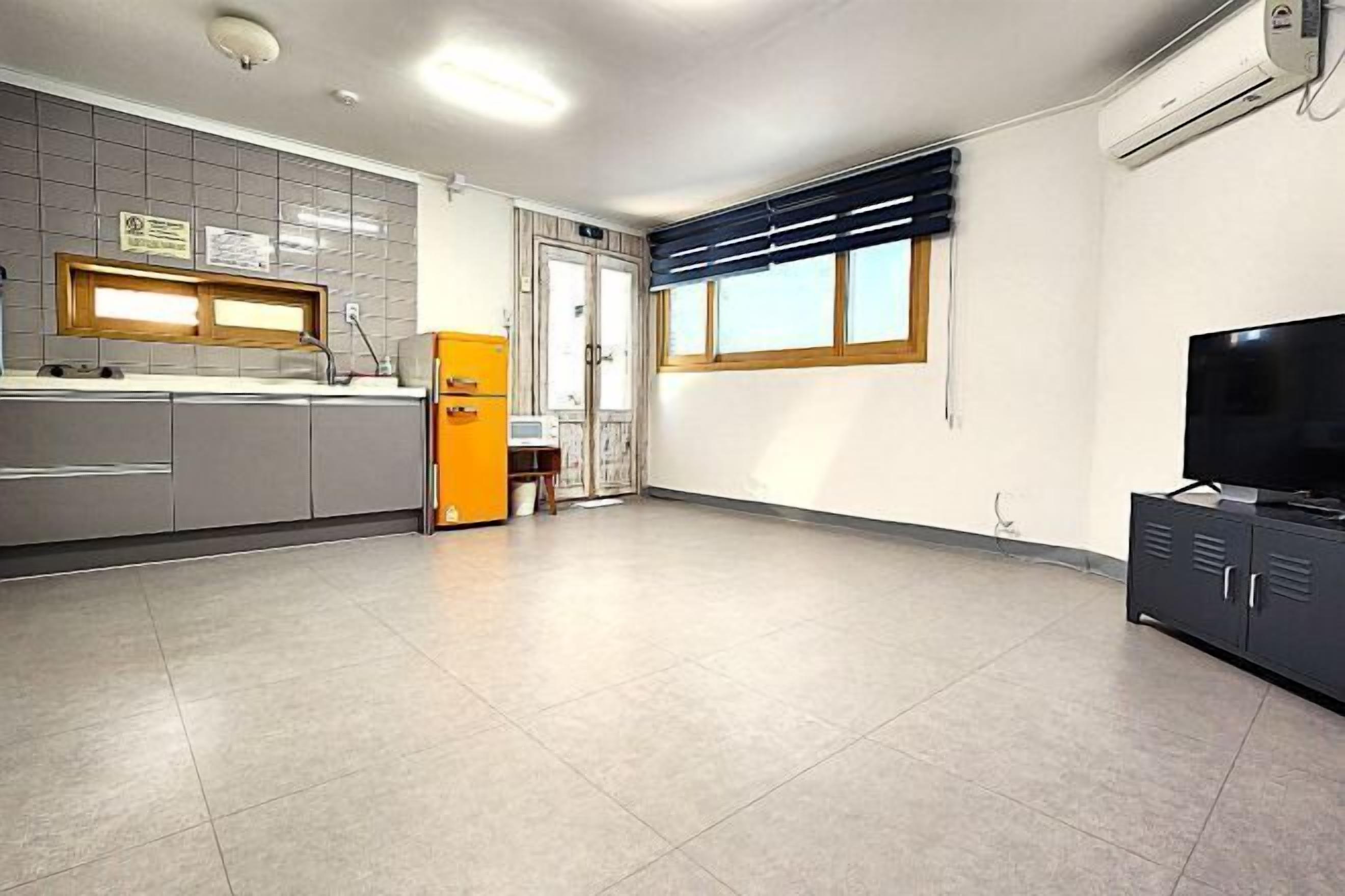A kitchen with a refrigerator, a sink, and a window.