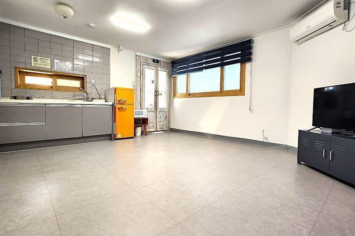A kitchen with a refrigerator, a sink, and a window.