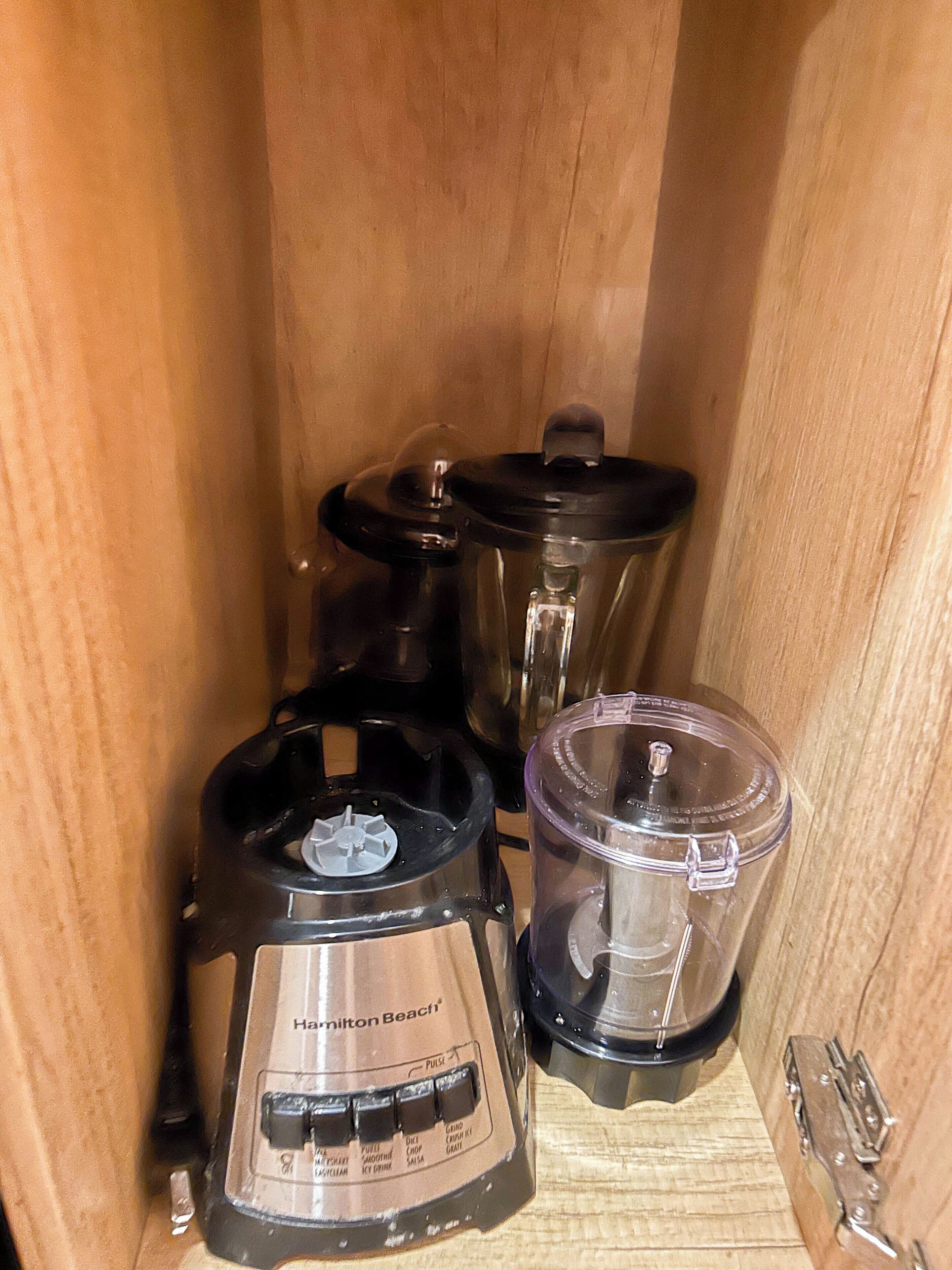 Una cocina con una licuadora, un procesador de alimentos y una cafetera.