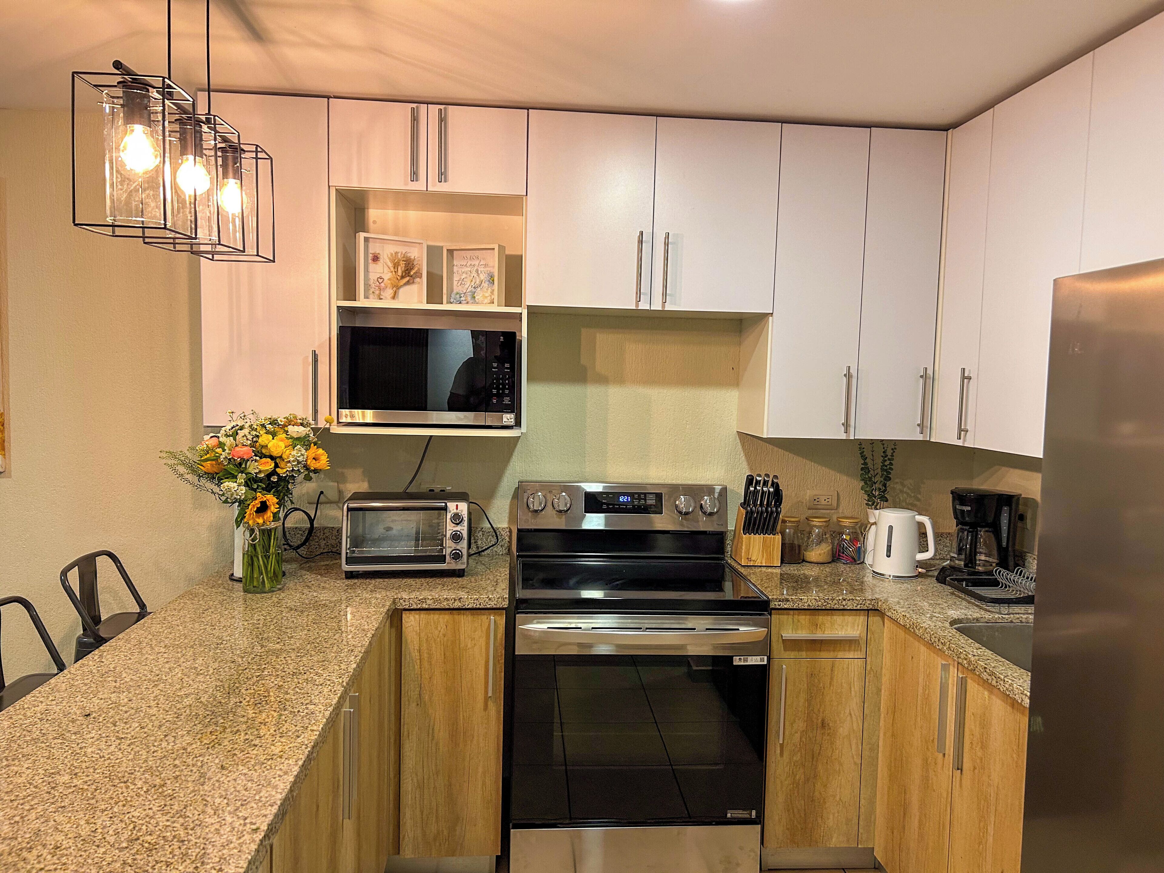 Una cucina moderna con forno a microonde, tostapane, forno e frigorifero.