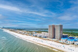 A coastal hotel with multiple high-rise buildings, beachfront access, and a pool area.