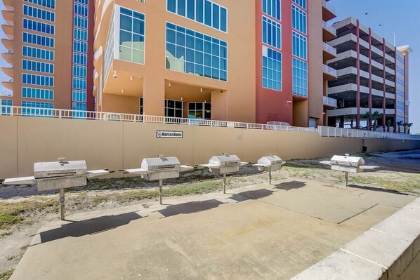 A building with multiple floors, a sign for 'Horseshoes', and outdoor barbecue grills.