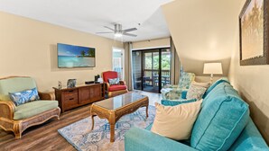 A living room with a ceiling fan, a large window, and a view of the outdoors. - Laurel Ct 307 in Kingston w/Elevator, Pool, Beach (Myrtle Beach)