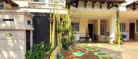 Un espace extérieur abrité, doté d’un sol carrelé, d’une pergola et d’un vélo.