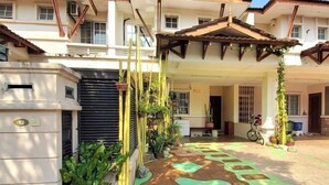 A residential building with a covered entrance, potted plants, and a pathway leading to the main door. - Putrajaya Transit Romestay (Putrajaya)