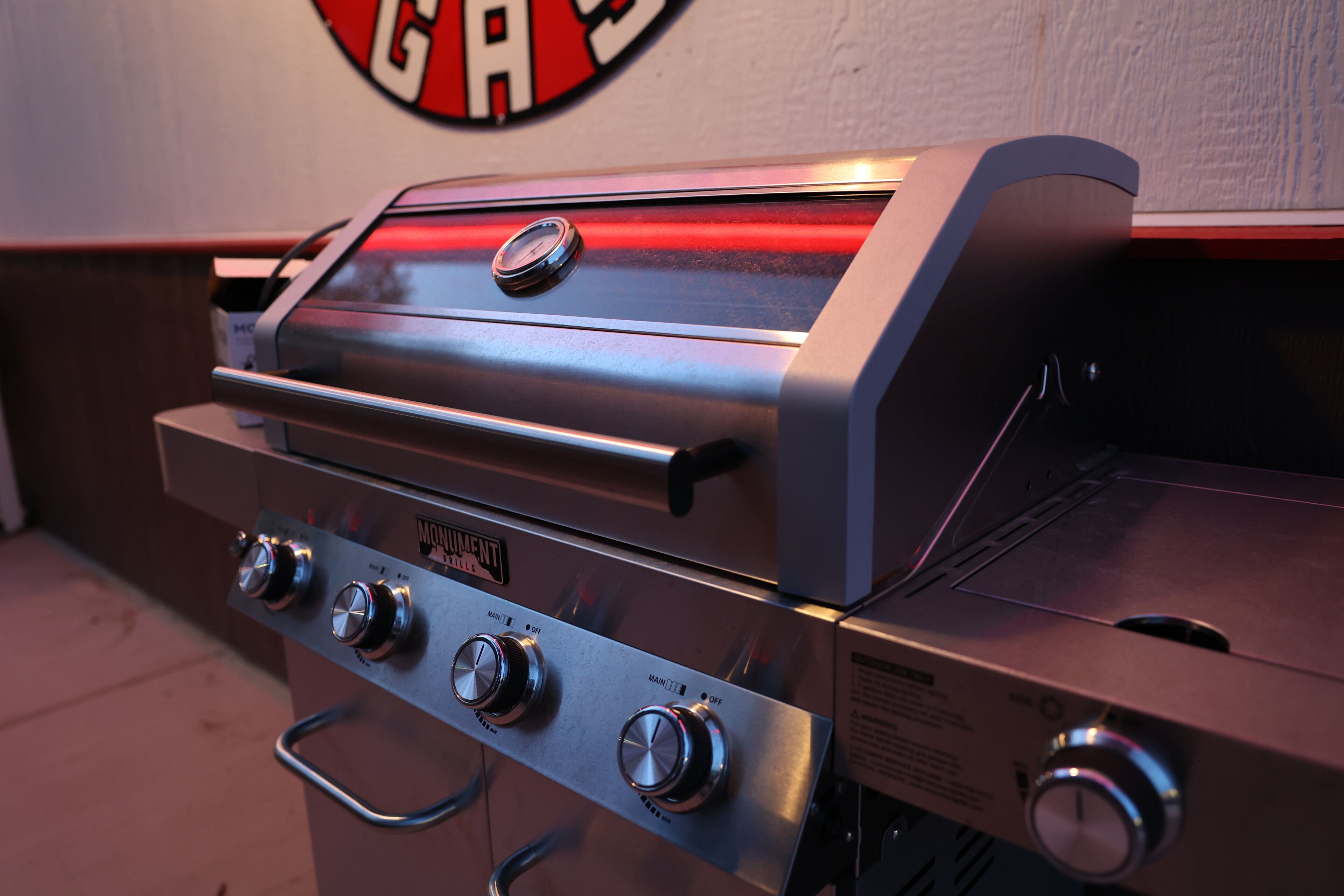 Un barbecue à gaz en acier inoxydable, doté de quatre brûleurs et d’un panneau de commande.