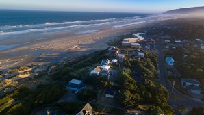 Luftaufnahme einer Küstenwohngegend mit Häusern, Straßen und einem Strand.