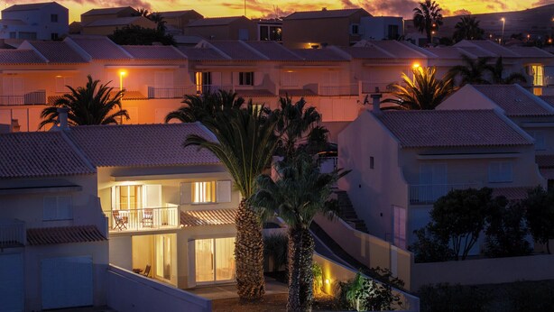Un quartier résidentiel composé de plusieurs maisons à deux étages, chacune dotée d’un balcon et d’une entrée bien visible.