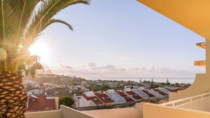 Un quartier résidentiel avec des maisons, un palmier et un ciel dégagé.