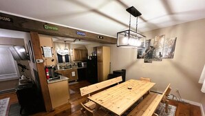 Eine moderne Küche mit Holzarbeitsplatten, einem eingebauten Backofen und einem Essbereich mit einem Holztisch und Bänken.