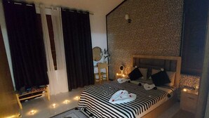 Et soveværelse med seng, sengebord og et dekorativt tæppe.