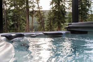 A hot tub surrounded by trees.