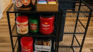 Angolo cottura con tavolo in legno, macchina per il caffè e microonde.
