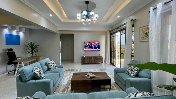 Una sala moderna con dos sofás, una mesa de centro y un televisor.