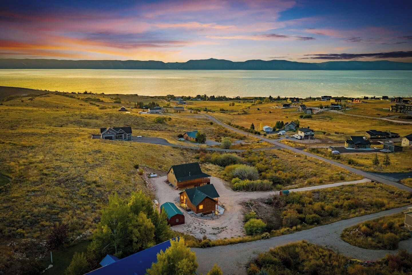 A rural landscape with houses and a lake.