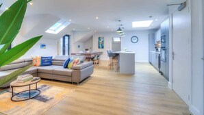 A modern apartment with a living area, dining space, and kitchen. - Penthouse Flat Manchester. 10 minutes to Airport. Sleeps 8. (Wythenshawe)