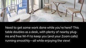 A room with a table that doubles as a desk, a TV, and a view of the outdoors. - Beachside Escape (Corpus Christi)
