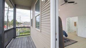 A covered porch with a view of the street, a glass door leading inside, and a ceiling fan. - Family-Friendly 10 Beds Stay NOLA (New Orleans)