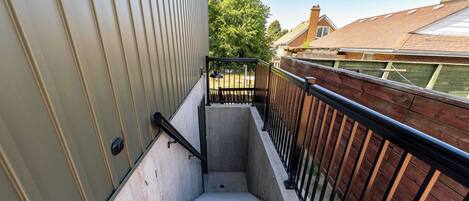 A concrete staircase with metal railings leading to a wooden deck.