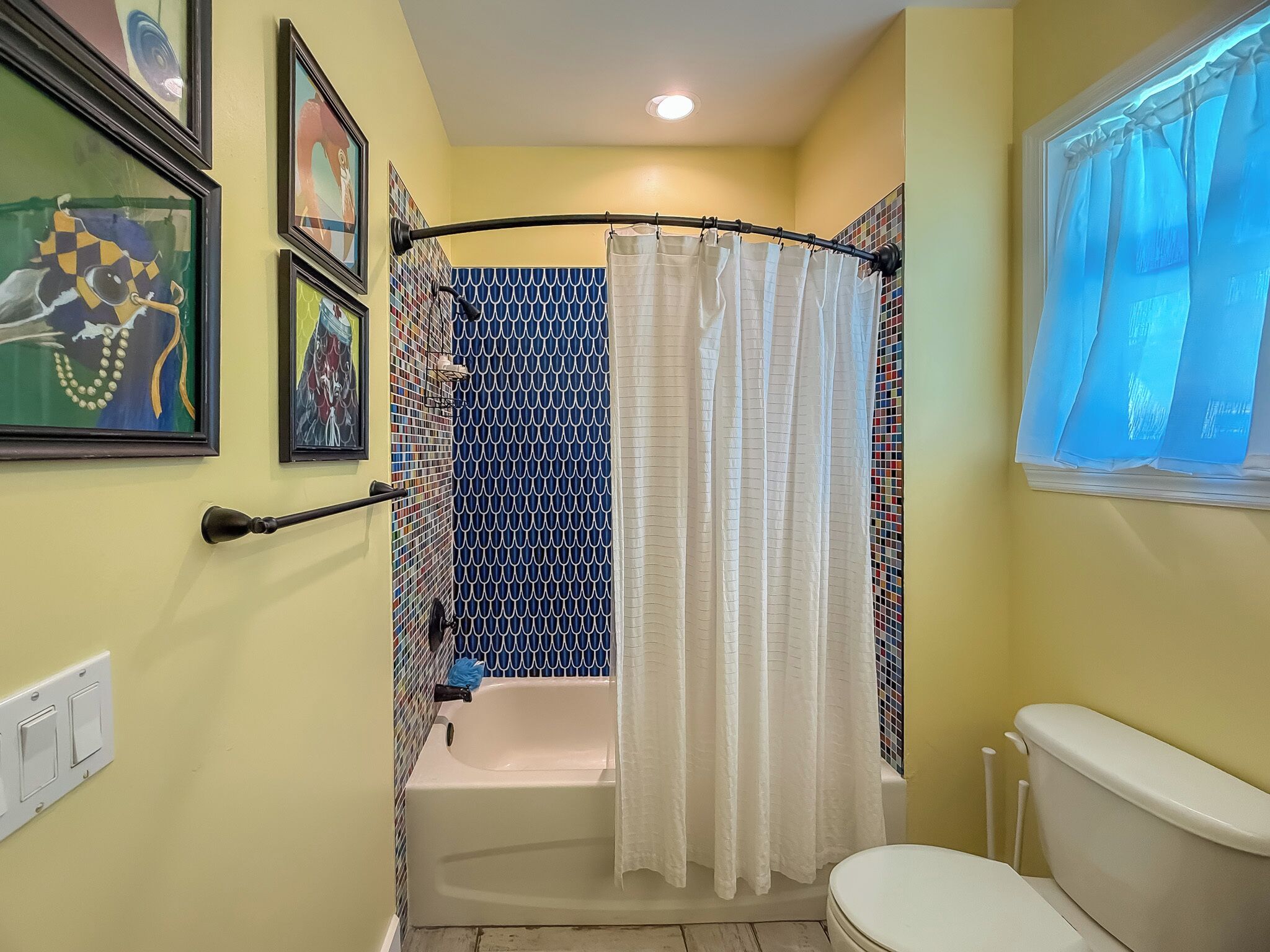 Un baño con bañera, inodoro y cortina de ducha.