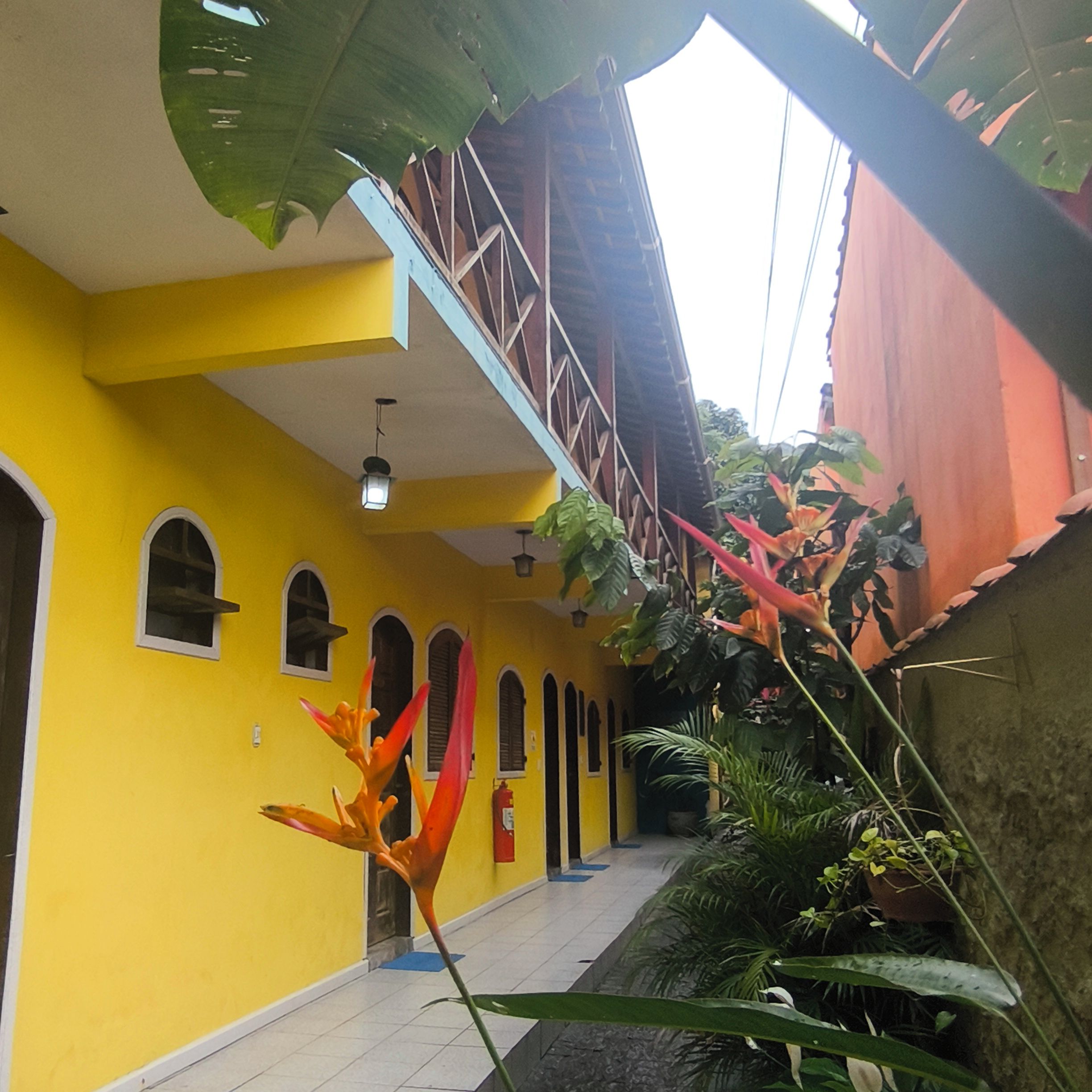 A yellow building with multiple arched windows and a staircase.