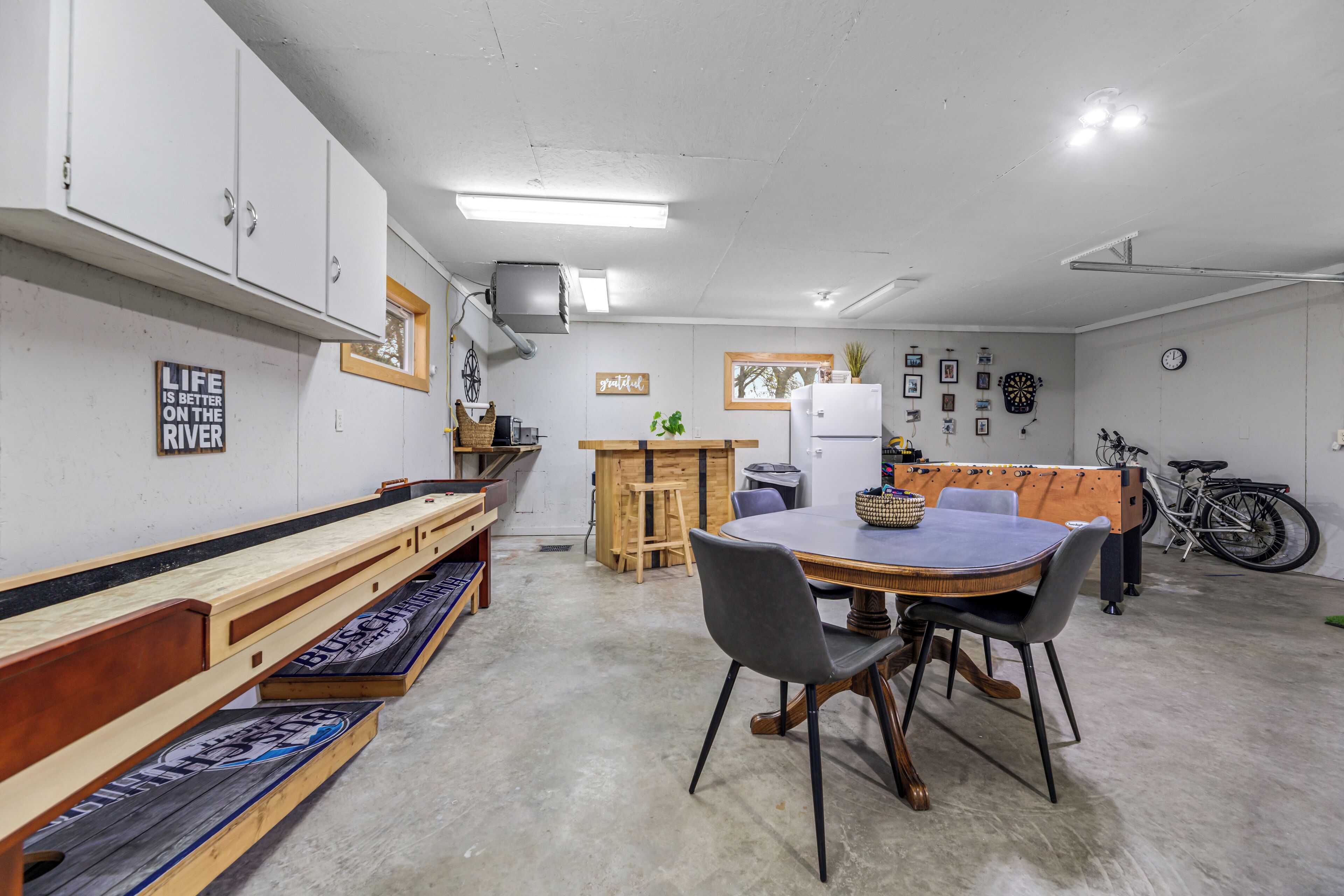 A compact kitchen with a dining table, benches, and a refrigerator.