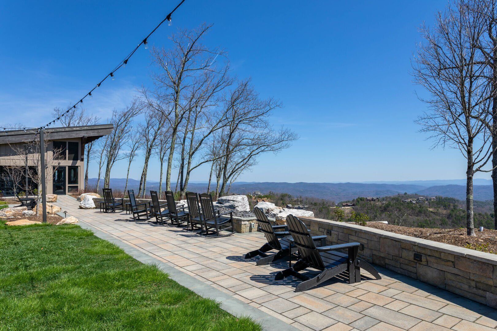 Une terrasse avec des sièges extérieurs et une vue sur les montagnes.