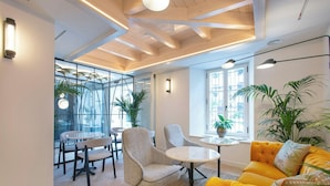 Un interior moderno con un sofá, sillas, una mesa y plantas en macetas.