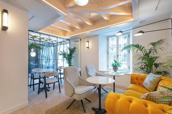 A modern interior with a sofa, chairs, a table, and potted plants. - La Fonda Heritage Hotel Relais and Chateaux (Marbella)