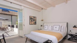 Un dormitorio con cama, mesitas de noche, escritorio y una silla.