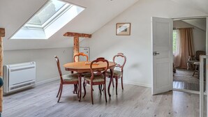 A dining area with a wooden table and chairs, a skylight, and a view of the outdoors. - 3 bedroom gorgeous home in Floby (Floby)