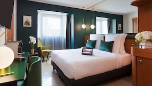 A hotel room with a large bed, a desk with a lamp, a chair, and a TV. - Bright Pool View Room in Cannes (Cannes)
