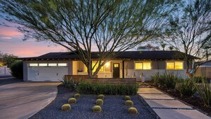A modern house with a garage, a well-maintained garden with cacti, and a driveway leading to the entrance. - Near Camelback Mtn, Old Town, Trails, Golf + Spas w/ Pool, Hot Tub Camelback Casa by Avantstay (Phoenix)