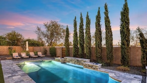 A swimming pool with stone tiles, lounge chairs, and tall trees in the background. - Near Camelback Mtn, Old Town, Trails, Golf + Spas w/ Pool, Hot Tub Camelback Casa by Avantstay (Phoenix)