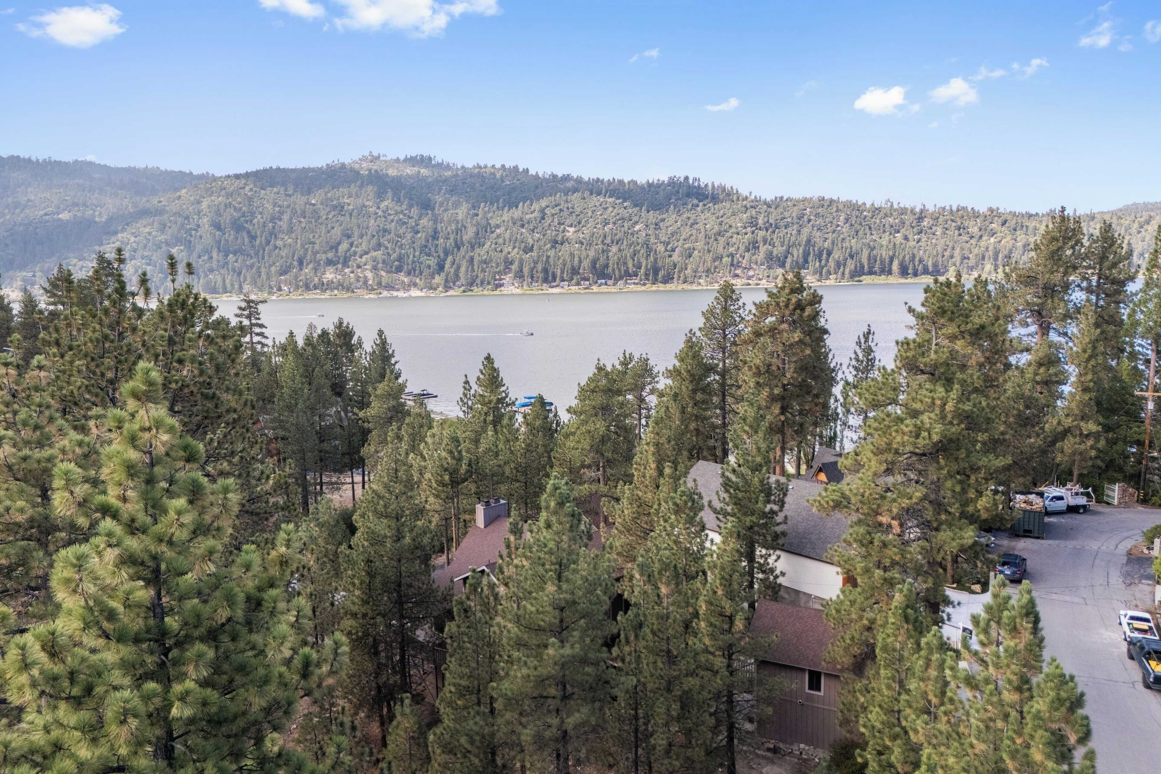 A view of a lake surrounded by dense forest and hills.