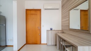 A modern kitchen with a built-in oven, a wooden door, and a wall-mounted air conditioner. - 1-bedroom Apartment 850 m From Masc - Cfe0503 (Florianópolis)