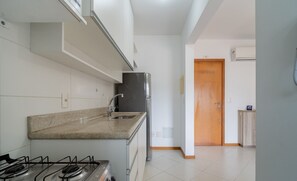 A kitchen with a gas stove, a sink, and a refrigerator. - 1-bedroom Apartment 850 m From Masc - Cfe0503 (Florianópolis)