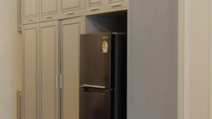 A kitchen with white cabinets and a black refrigerator. - Warm and Classic Modern Room (Chiang Mai)