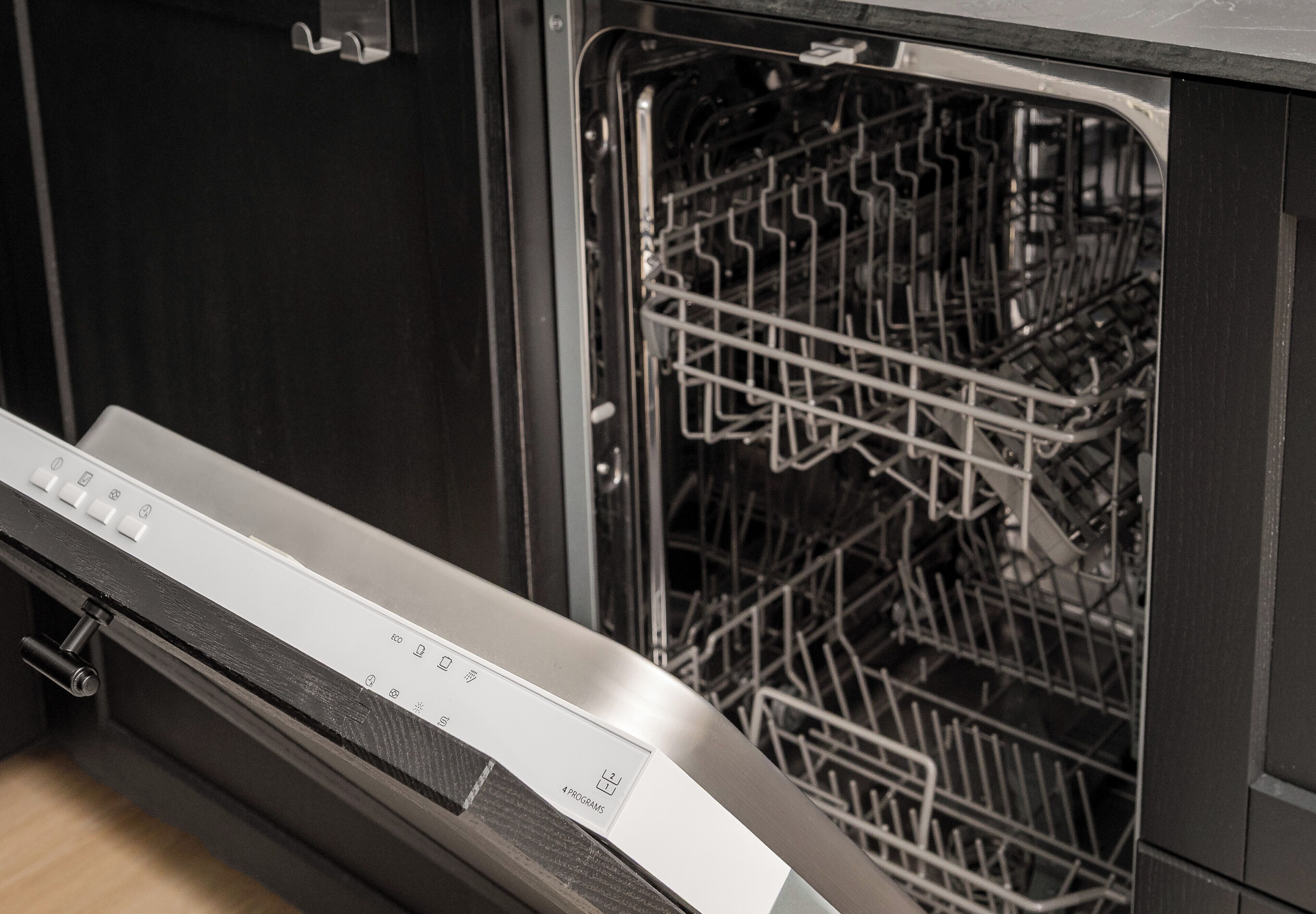 A dishwasher with a control panel and a door that is partially open, revealing the interior racks.