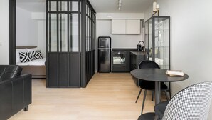 Un espacio habitable compacto con kitchenette, comedor y sofá.