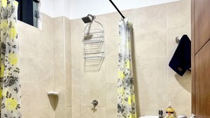 A bathroom with a shower, toilet, and sink. - Cozy apartment (Leticia)