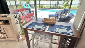 Un'area patio con piscina, mobili da esterno e un tavolo con tovagliette.